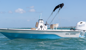 sea-born-fx21-bay-sharkin-blue-at-rest-with-bimini-top-and-suzuki-outboard